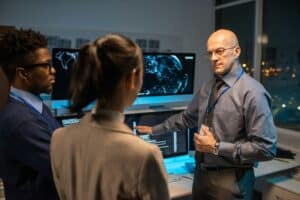 Bald mature director of software company giving instructions to his subordinates